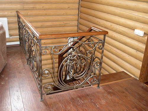 Деревянная лестница с кованым ограждением. Верхняя площадка